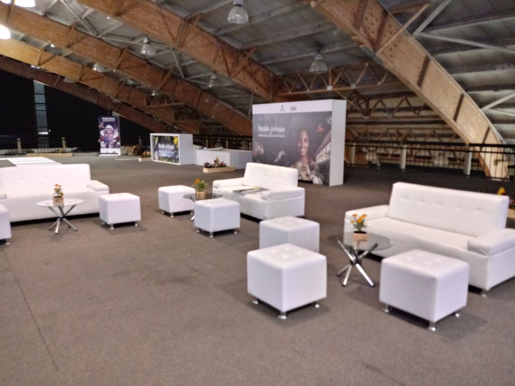 Sala lounge moderna con sofás y mesa central para evento